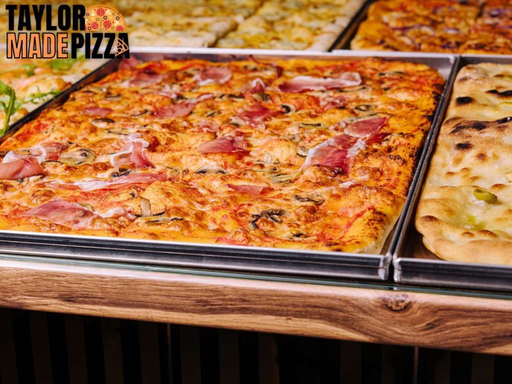 A selection of square pizzas cooked in trays served by the slice.