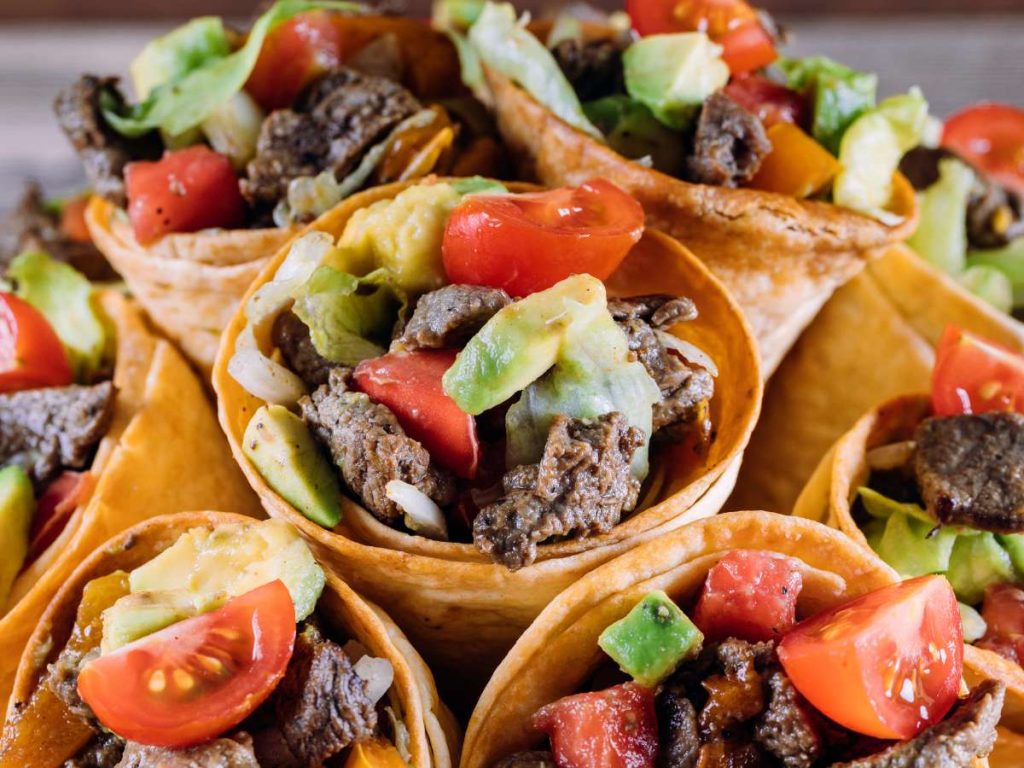 A closeup shot of taco cones filled with ingredients.